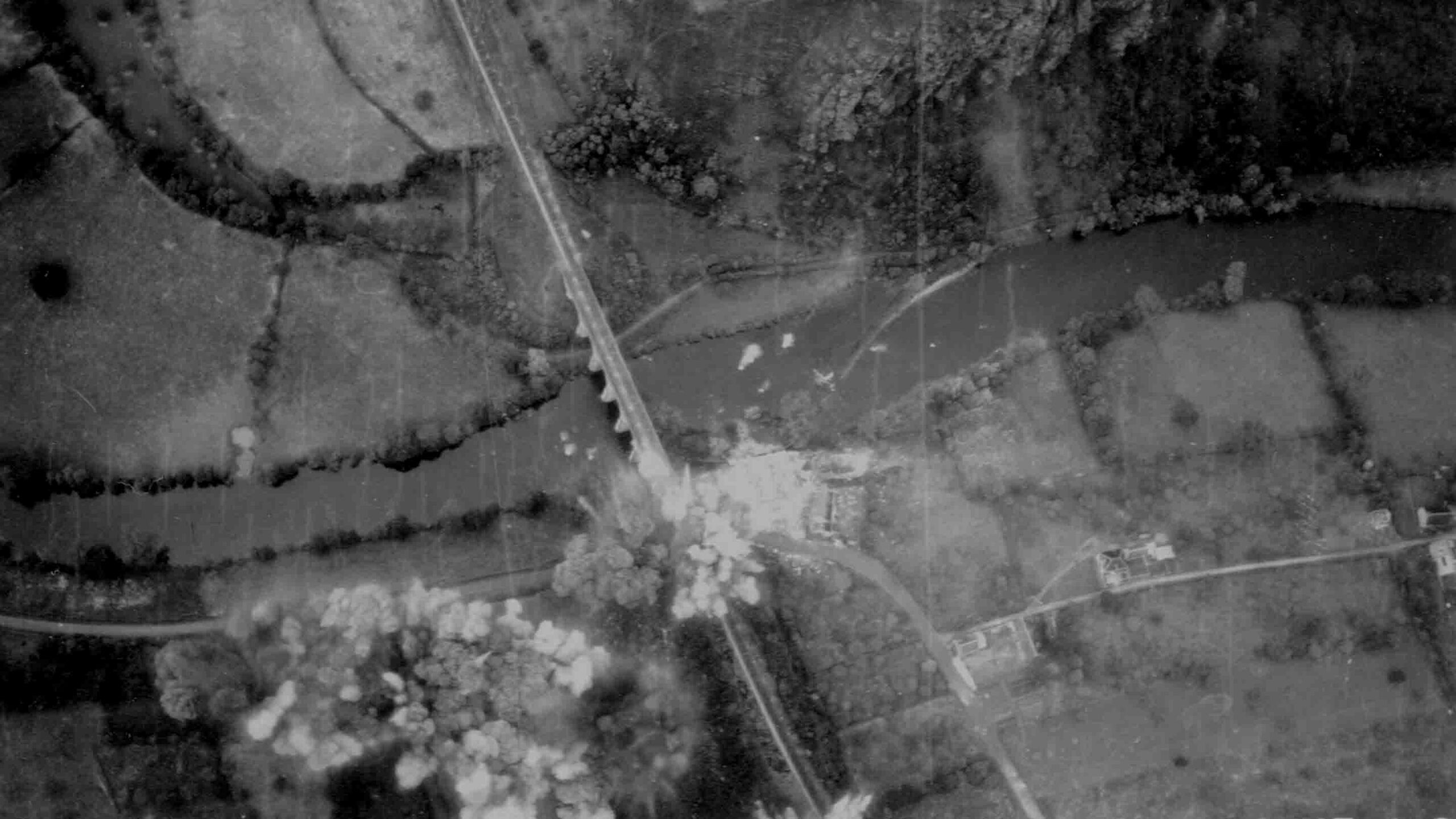Aerial view of a bombing raid targeting a bridge.