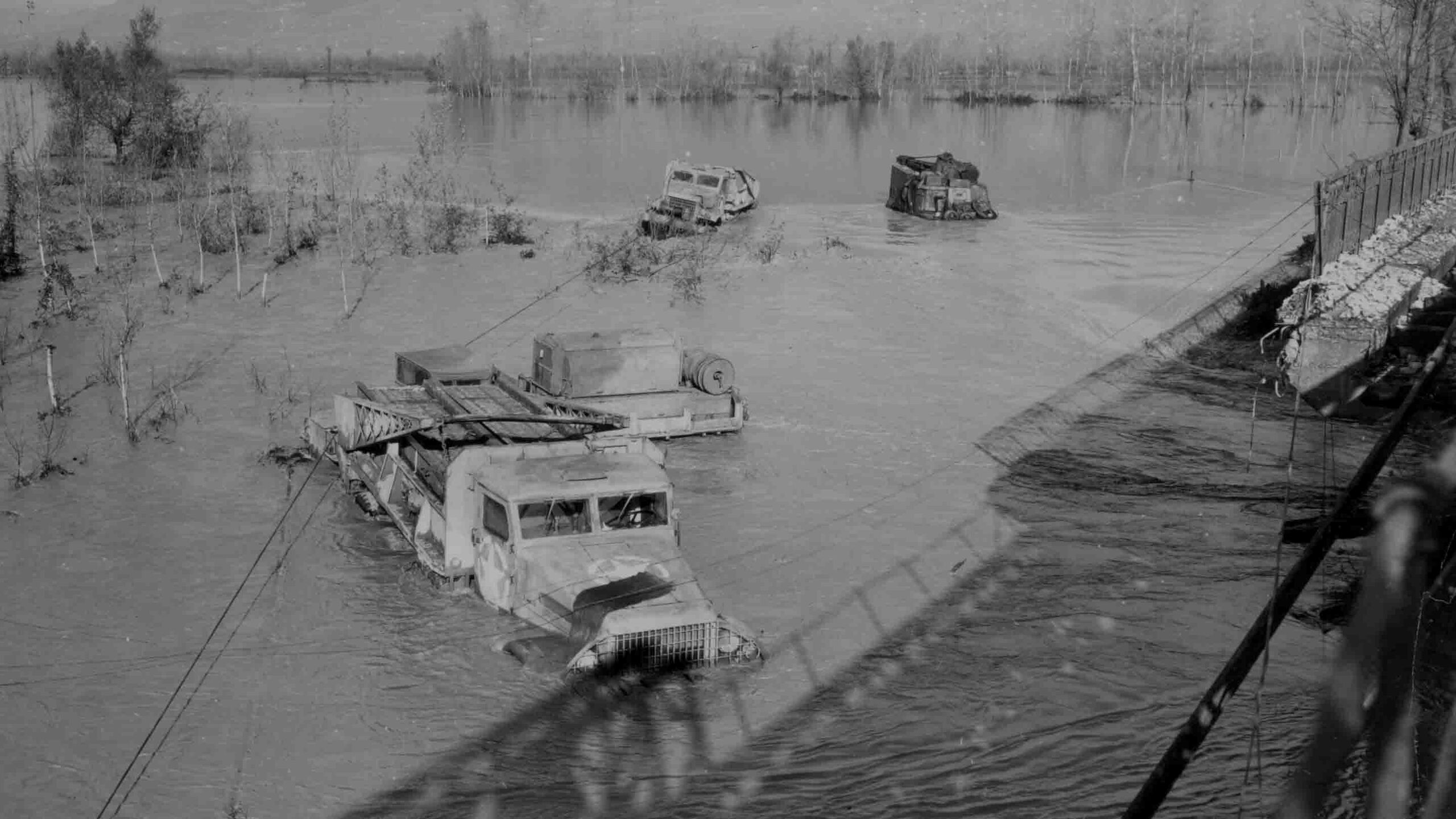 U.S. Army trucks stranded in the rising floodwaters of the Volturno River, which surged 12 feet in four hours.