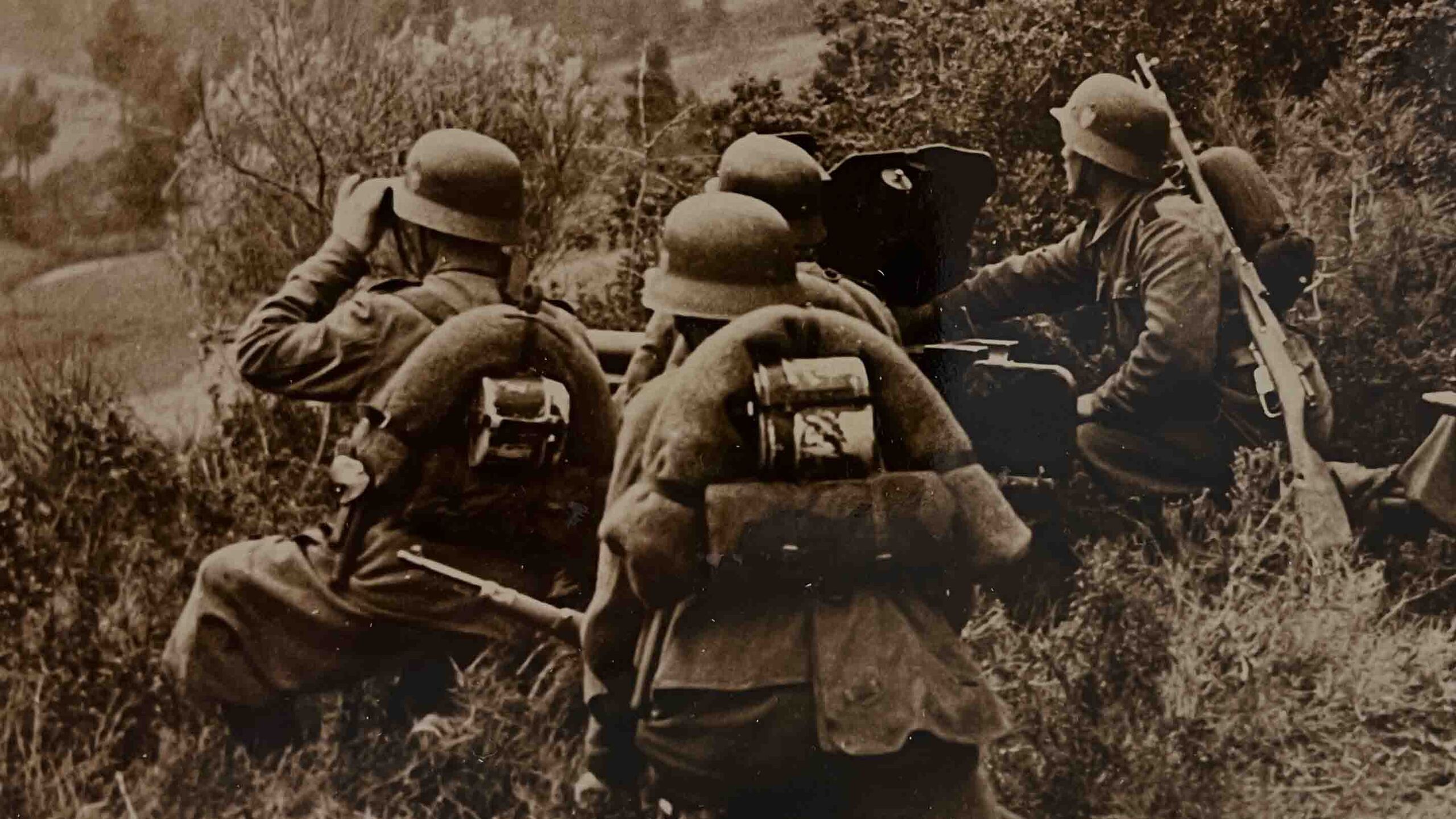 German soldiers conceal themselves while scanning the horizon for targets.