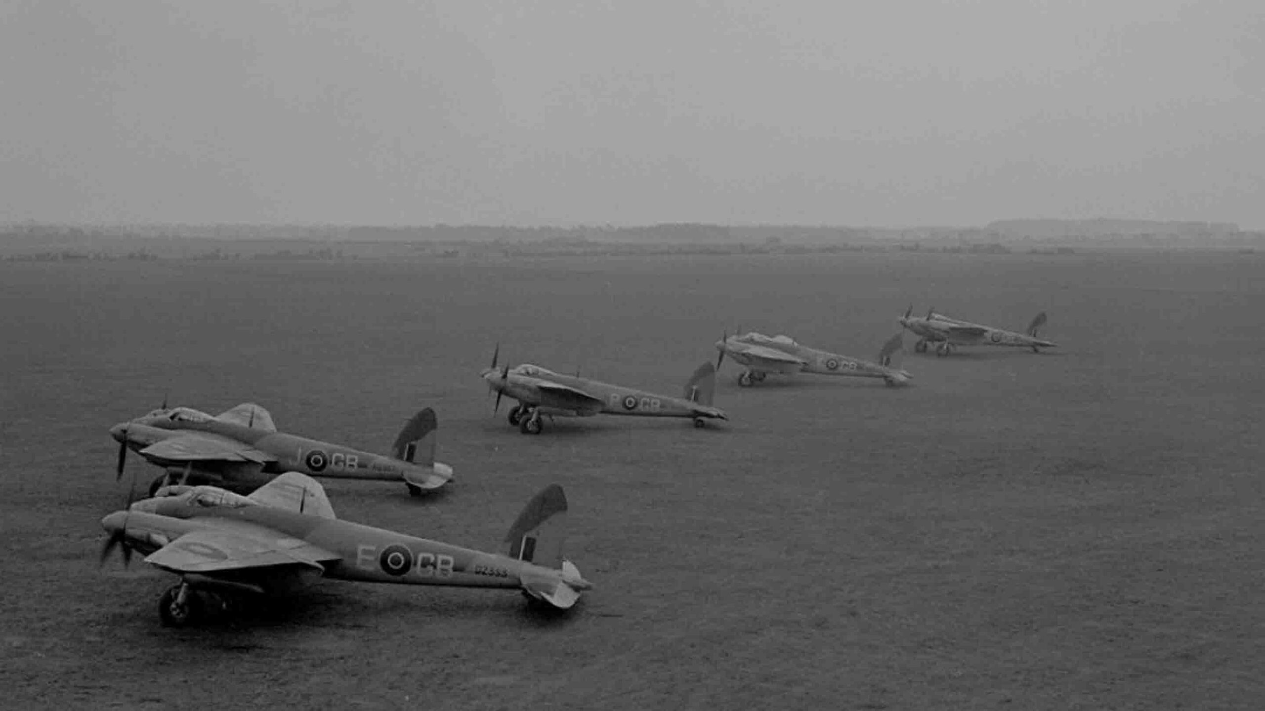 WW2 Raf Mosquito's lined up on a grass airfield, date and location unknown.