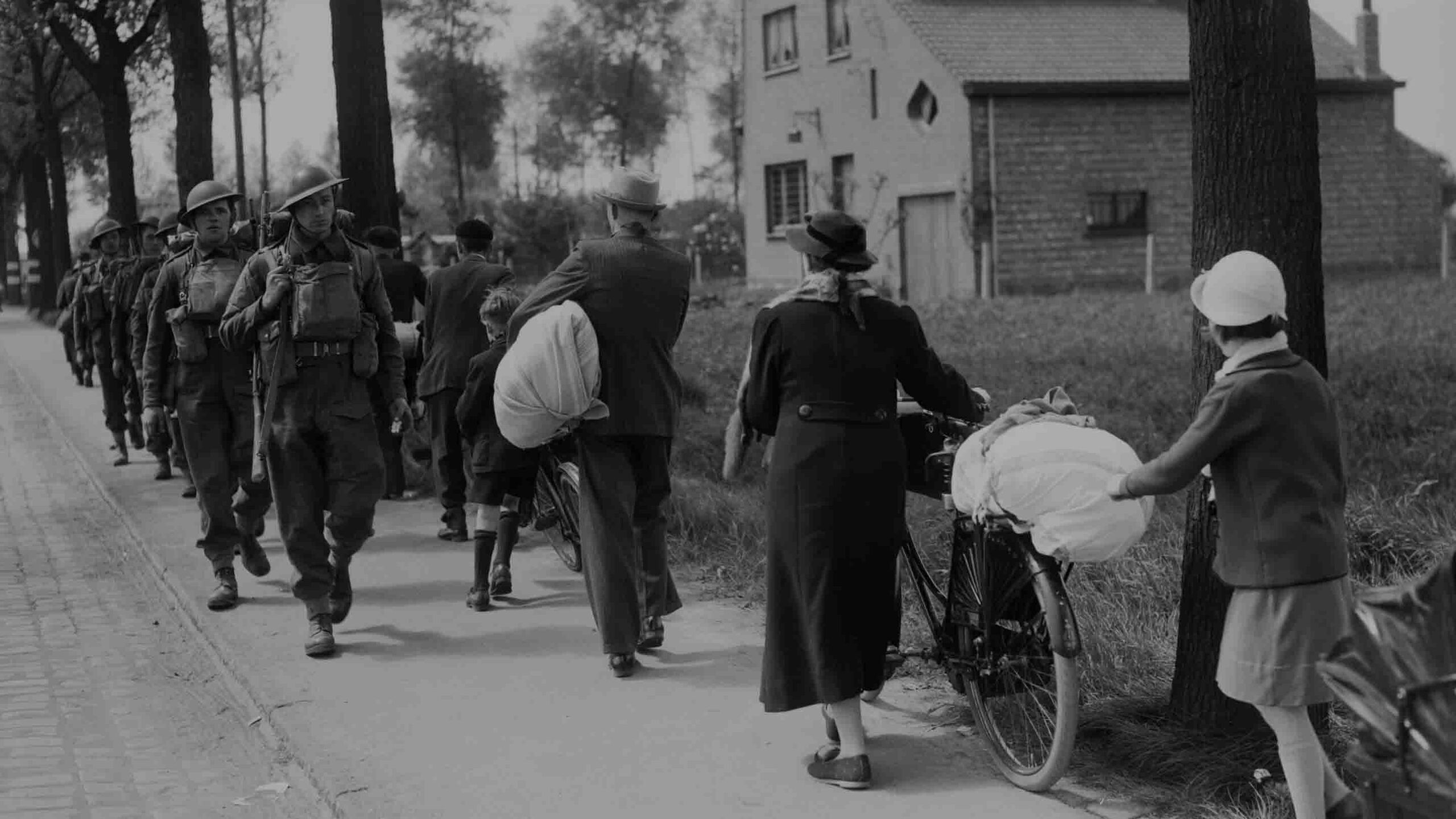 British troops march past Belgian refugees on the Brussels-Louvain road, 12 May 1940, during the Battle of France.