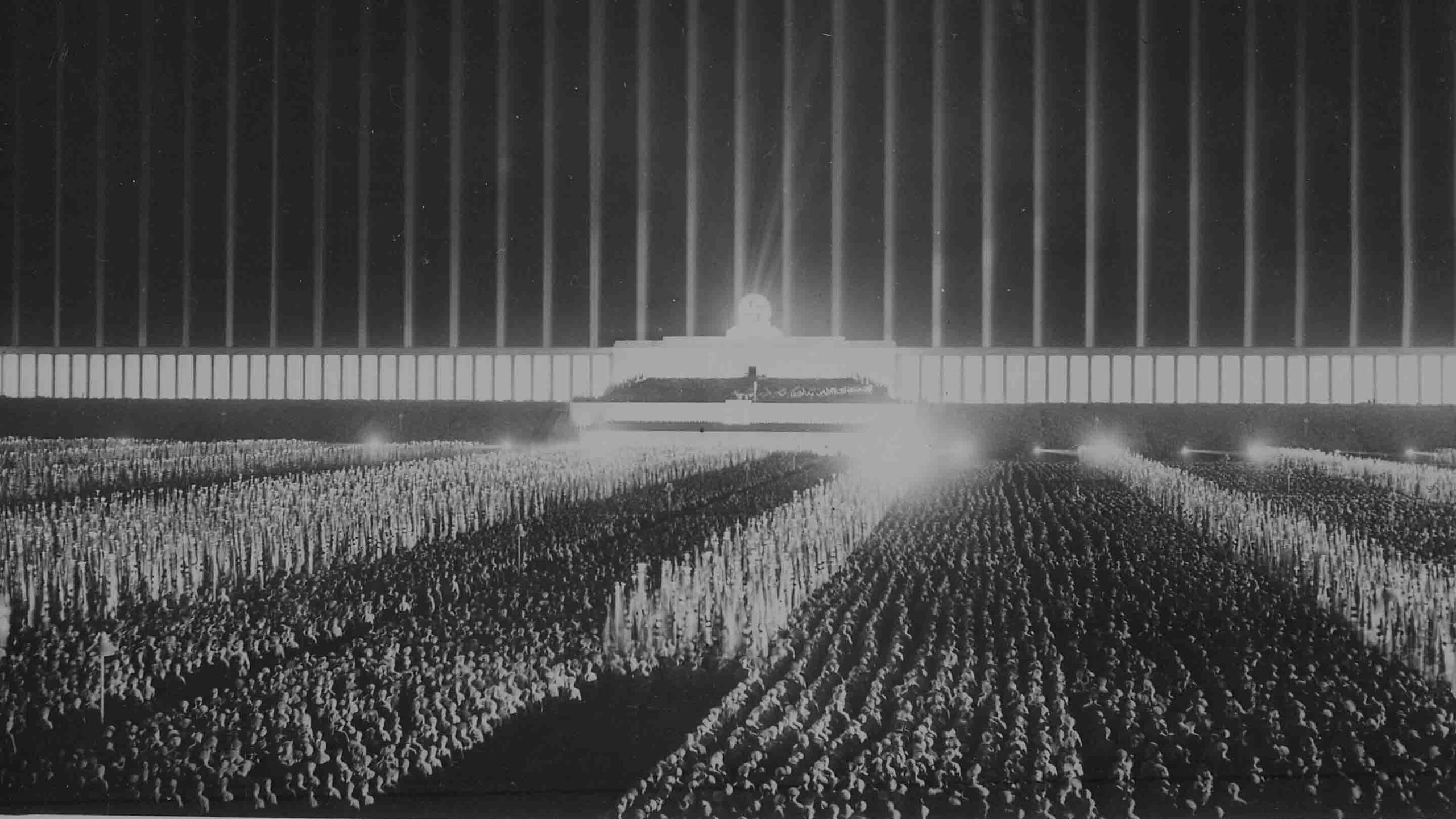 A mass assemblage of political leaders gathered on the searchlight-illuminated Zeppelin Field in Nuremberg during the Reichsparteitag, September 1937.