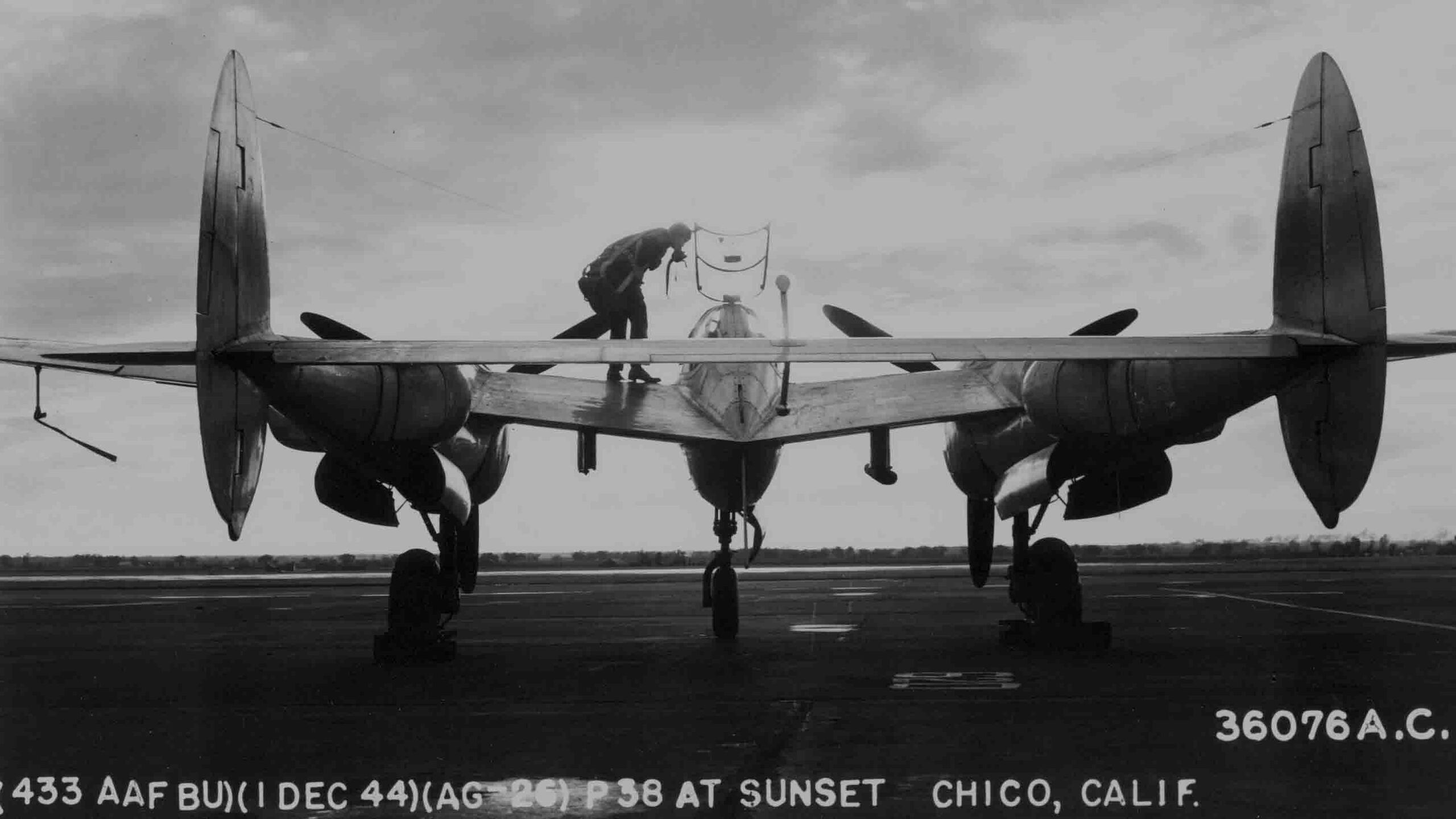 P-38 at Sunset, December 1944 – A Lockheed P-38 Lightning silhouetted against the evening sky.